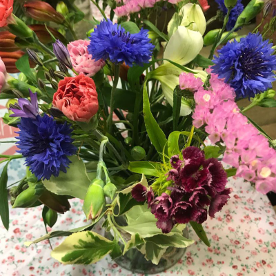 The Happy Vase - Happy Vase floral arrangement, made up of bright blooms and leaves.